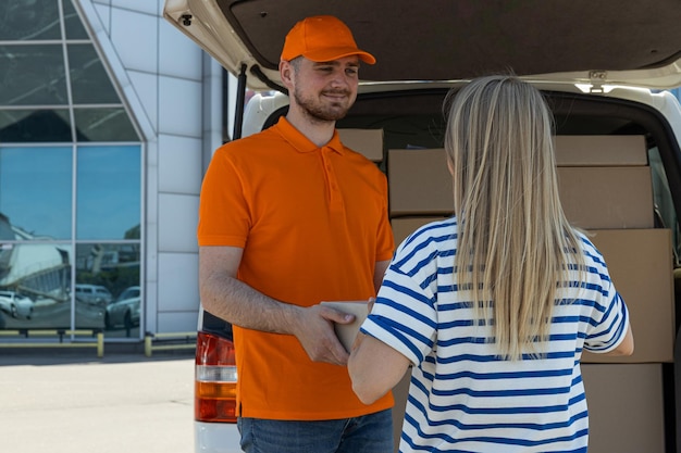 courier gives parcel client near car with parcels 185193 137009